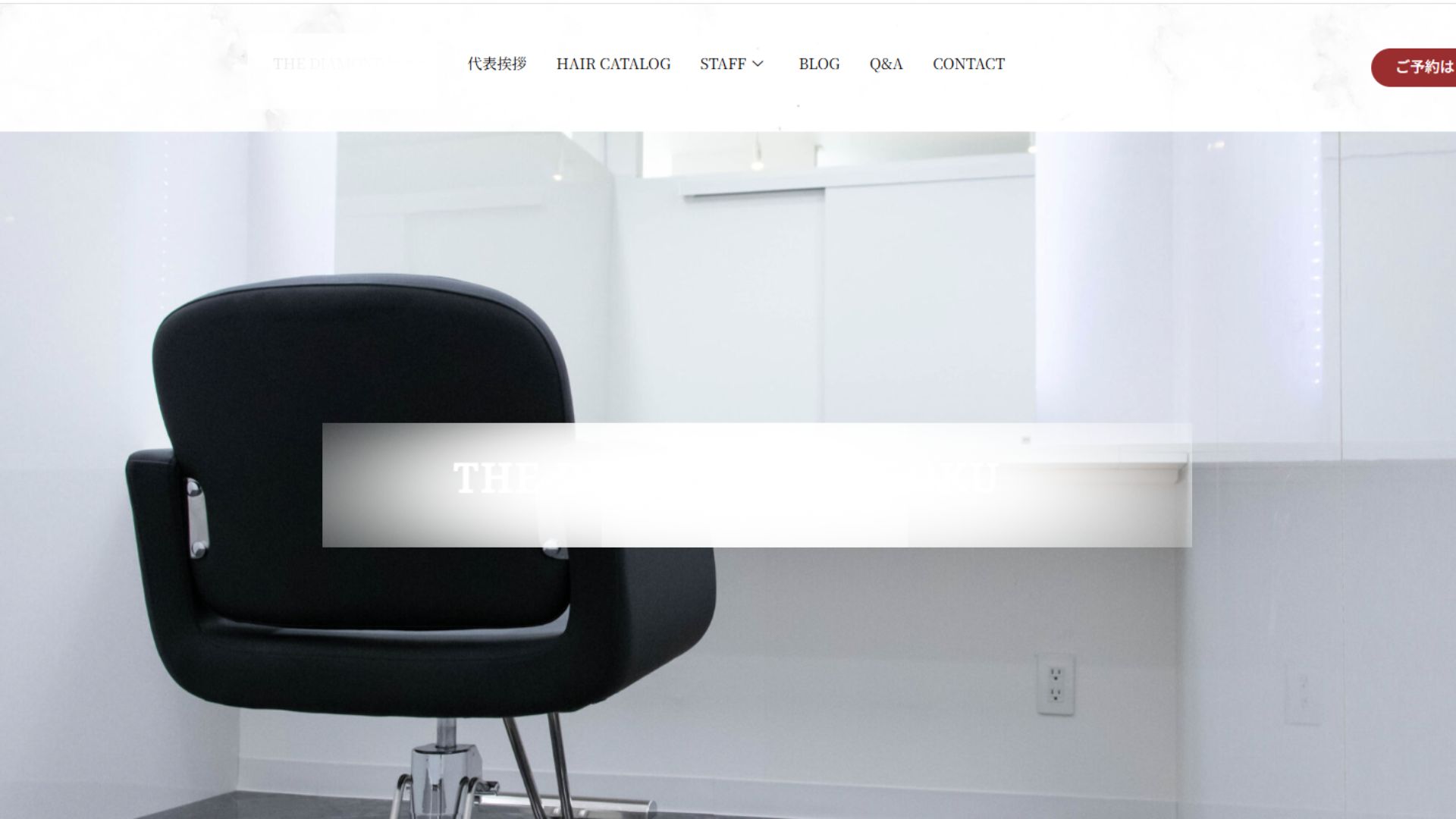 白を基調とした美容室のカットスペース。黒い施術チェアが配置された清潔感と高級感のあるヘアサロンの内装写真。